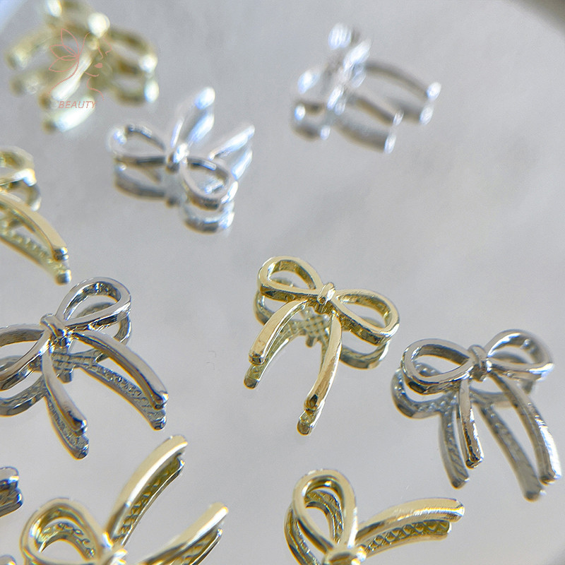[maybeauty] 10pcs Bow Deco Nail Art Charm 3D Silver/Gold Bowknot Ribbon Nail Decor Parts DIY อุปกรณ์ทําเล็บ {TH}