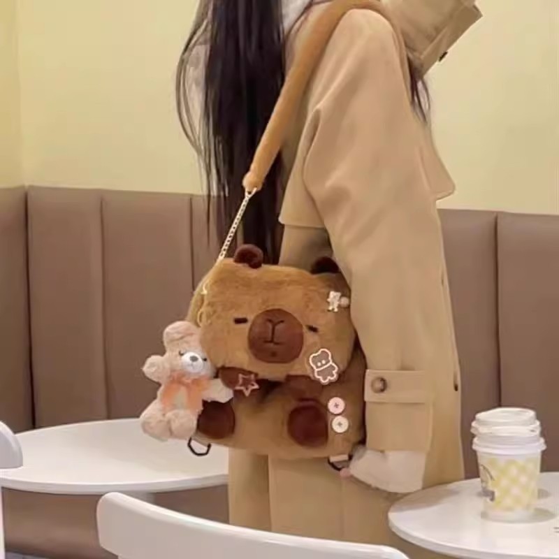 กระเป๋าเป้สะพายหลังตุ๊กตา Capibala น่ารัก Ins ใหม่สาวหัวใจโง่น่ารัก Capybara นักศึกษาวิทยาลัยกระเป๋าสะพายข้างอุปกรณ์ต่อพ่วงแฟชั่น