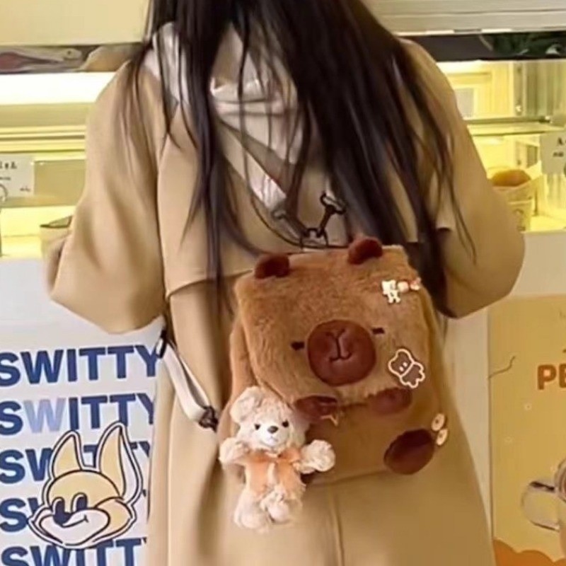 กระเป๋าเป้สะพายหลังตุ๊กตา Capibala น่ารัก Ins ใหม่สาวหัวใจโง่น่ารัก Capybara นักศึกษาวิทยาลัยกระเป๋าสะพายข้างอุปกรณ์ต่อพ่วงแฟชั่น