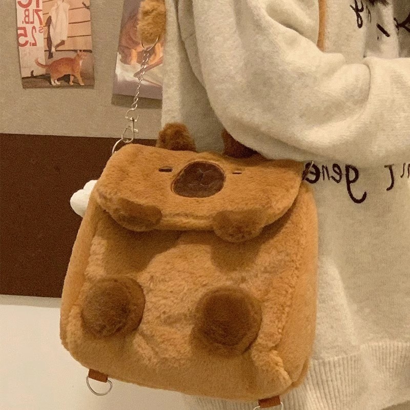 กระเป๋าเป้สะพายหลังตุ๊กตา Capibala น่ารัก Ins ใหม่สาวหัวใจโง่น่ารัก Capybara นักศึกษาวิทยาลัยกระเป๋าสะพายข้างอุปกรณ์ต่อพ่วงแฟชั่น