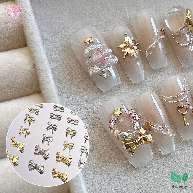 Heabety 10PCS เล็บ Ch 3D คริสตัล Rhinestones Bow Nail Art เครื่องประดับโลหะผสม Bow Tie Gold Shinny เล็บอุปกรณ์เสริม Salon เล็บเครื่องมือใหม่