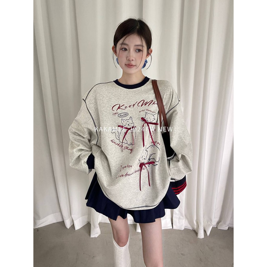 การ์ตูนแมวพิมพ์โบว์แขนยาวเสื้อยืดสําหรับความรู้สึกการออกแบบใหม่ของผู้หญิงสีตัดกันหลวมด้านบน
