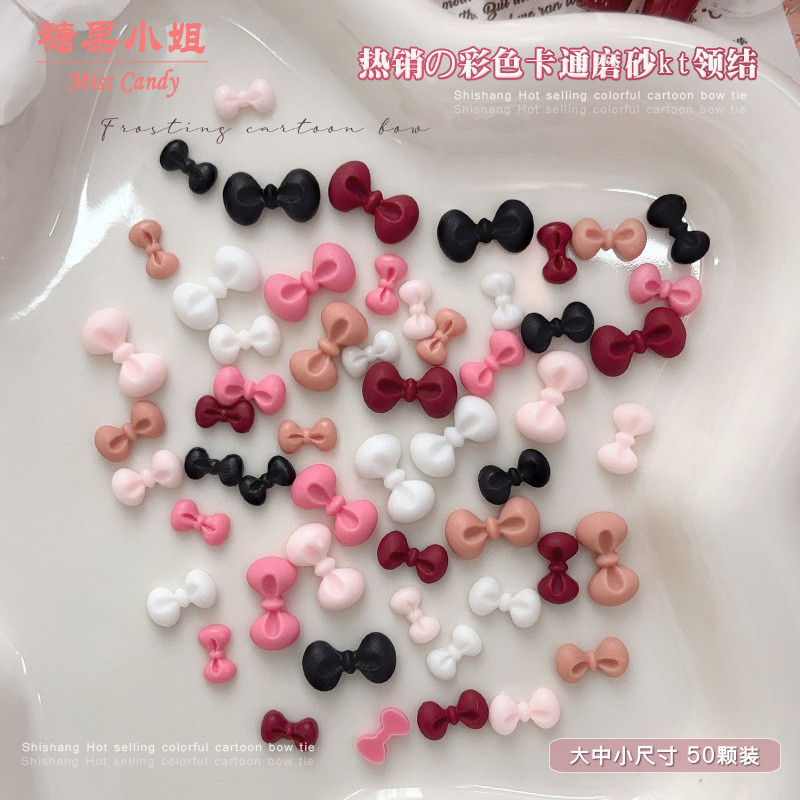 50 ชิ้น อุปกรณ์ตกแต่งเล็บโบว์ KT ลายการ์ตูนผสม สีดำ ขาว แดงไวน์ และชมพู เพชรเรซินผสม