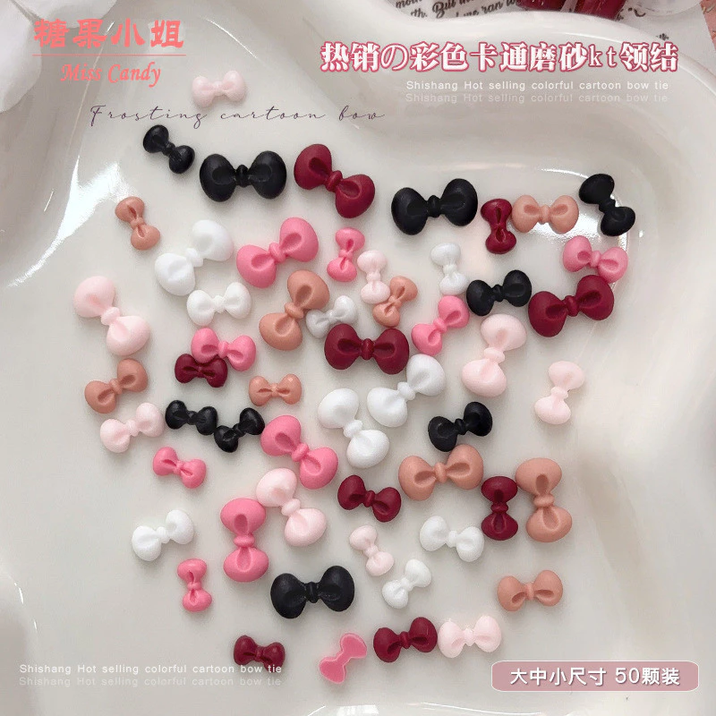 50 ชิ้น อุปกรณ์ตกแต่งเล็บโบว์ KT ลายการ์ตูนผสม สีดำ ขาว แดงไวน์ และชมพู เพชรเรซินผสม