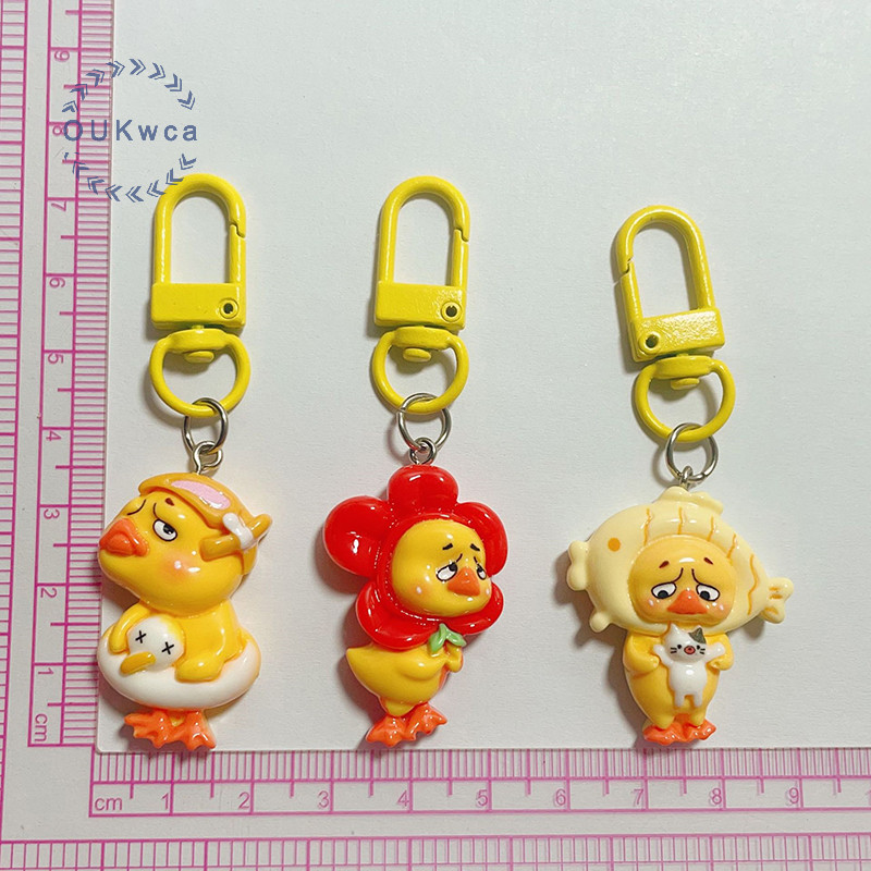 อุ๊ย ย่นคิ้วถือแมวหัวปลาเป็ดสีเหลืองพวงกุญแจเรซิ่นสาวหัวใจจี้กระเป๋าแขวนอุปกรณ์เสริมเด็กของขวัญใหม่