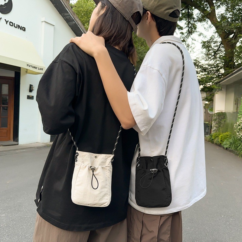 ญี่ปุ่นและเกาหลีไนลอนวัสดุเชือกดึงสีทึบผู้ชายและผู้หญิงสไตล์เดียวกันกระเป๋า messenger แฟชั่นคู่...