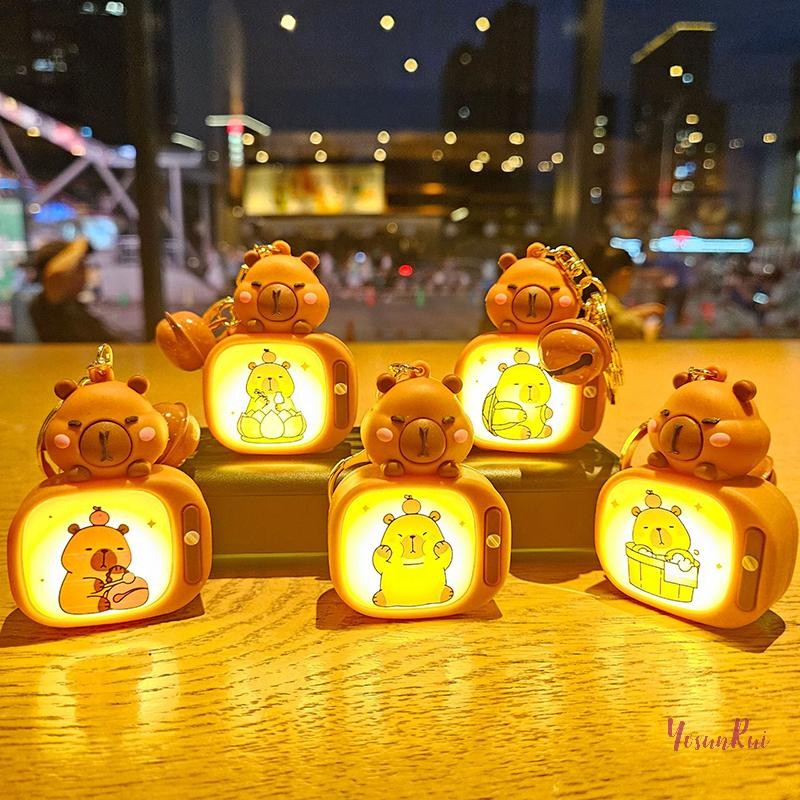 Yosunrui] การ์ตูนน่ารัก Capybara ทีวีพร้อมแสงสร้างสรรค์ตลกสัตว์พวงกุญแจรถพวงกุญแจกระเป๋าเป้สะพายหลังจี้สําหรับเด็กเครื่องประดับของขวัญใหม่