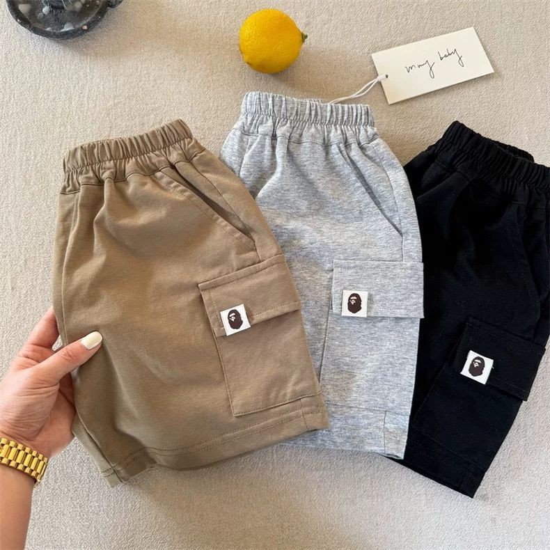 เด็กชายฤดูร้อนสไตล์ใหม่แฟชั่นเกาหลีรุ่นผ้าฝ้ายแท้เรียบง่ายสีทึบกระเป๋าแพทช์ลายหลวมหล่อลําลองหลวมกางเกงขาสั้น