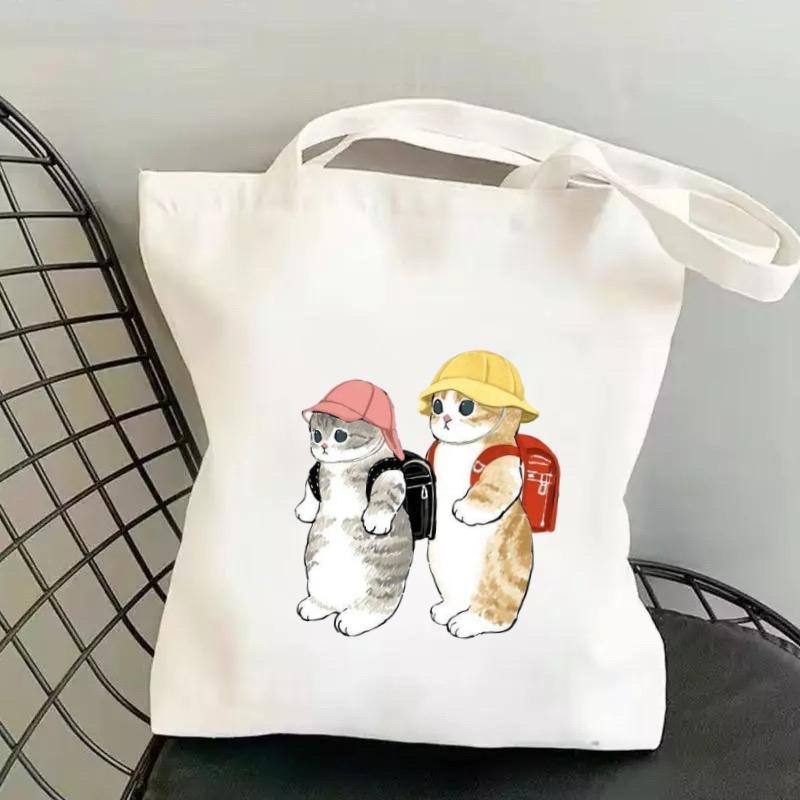 กระเป๋าผ้าลายแมวน่ารักใบใหม่นี้ โดดเด่นด้วยดีไซน์เรียบง่าย ความจุขนาดใหญ่ และลวดลายสกรีนที่หลากหลาย ขนาด: 34*37 ซม.