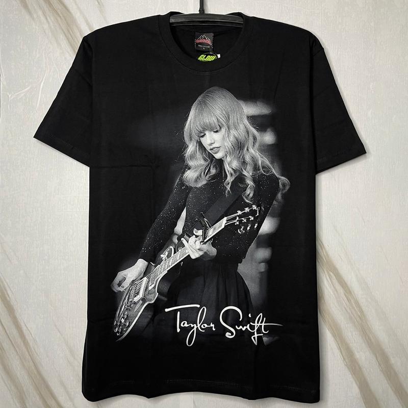 เสื้อยืด Taylor Swift เทย์เลอร์ สวิฟต์ เล่นกีต้าร์ หลังเล่นเปียโน คุมโทนเทาดำ (ป้าย RockTees เรืองแส