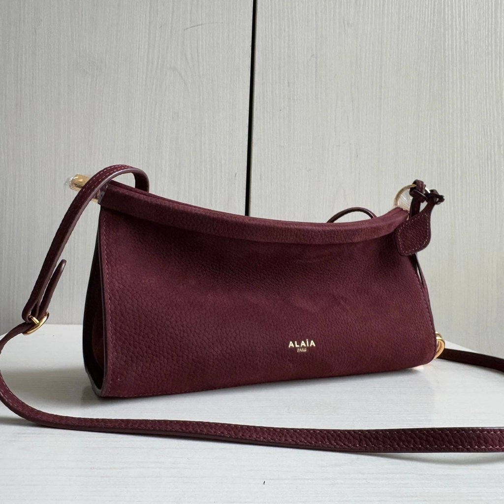 กระเป๋าคลิปหนังวัวเคลือบเงางามแบบโค้ง Alaia พร้อมสายสะพายแนวนอน