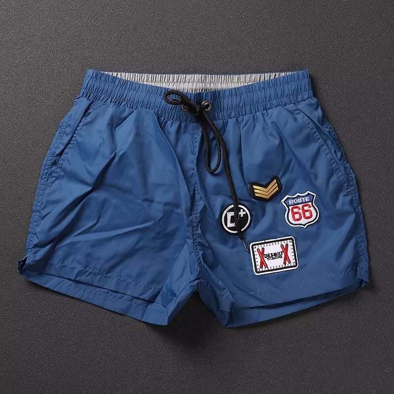 Street Wear ฤดูร้อนบางสไตล์ Quick-Drying กางเกงสามจุดผู้ชายสไตล์ใหม่หลวมสบายๆ All-Match สีทึบปักป้ายกีฬากางเกงขาสั้น