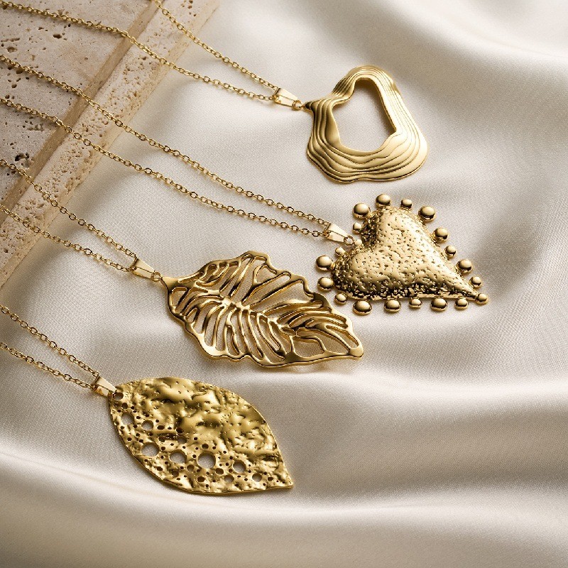 Retro สแตนเลสสตีลชุบ 18K Gold สามมิติ Hollow รูปแบบใบไม่สม่ําเสมอสร้อยคอจี้หัวใจ 26.21