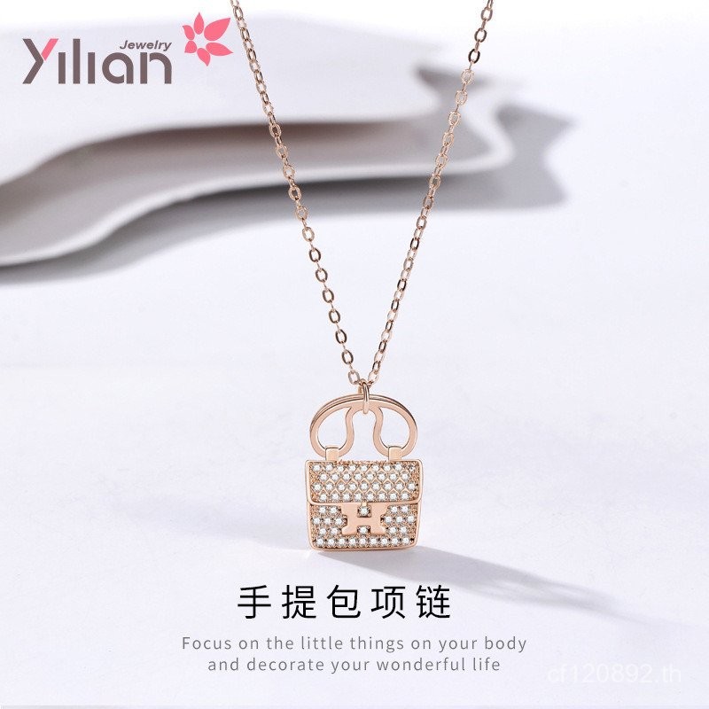 กระเป๋าถือฝังเพชรและสร้อยคอนามธรรม ลายอักษรภาษาอังกฤษ ออกแบบด้วยจี้เงินสเตอร์ลิง และสายโซ่กระดูกไหปล