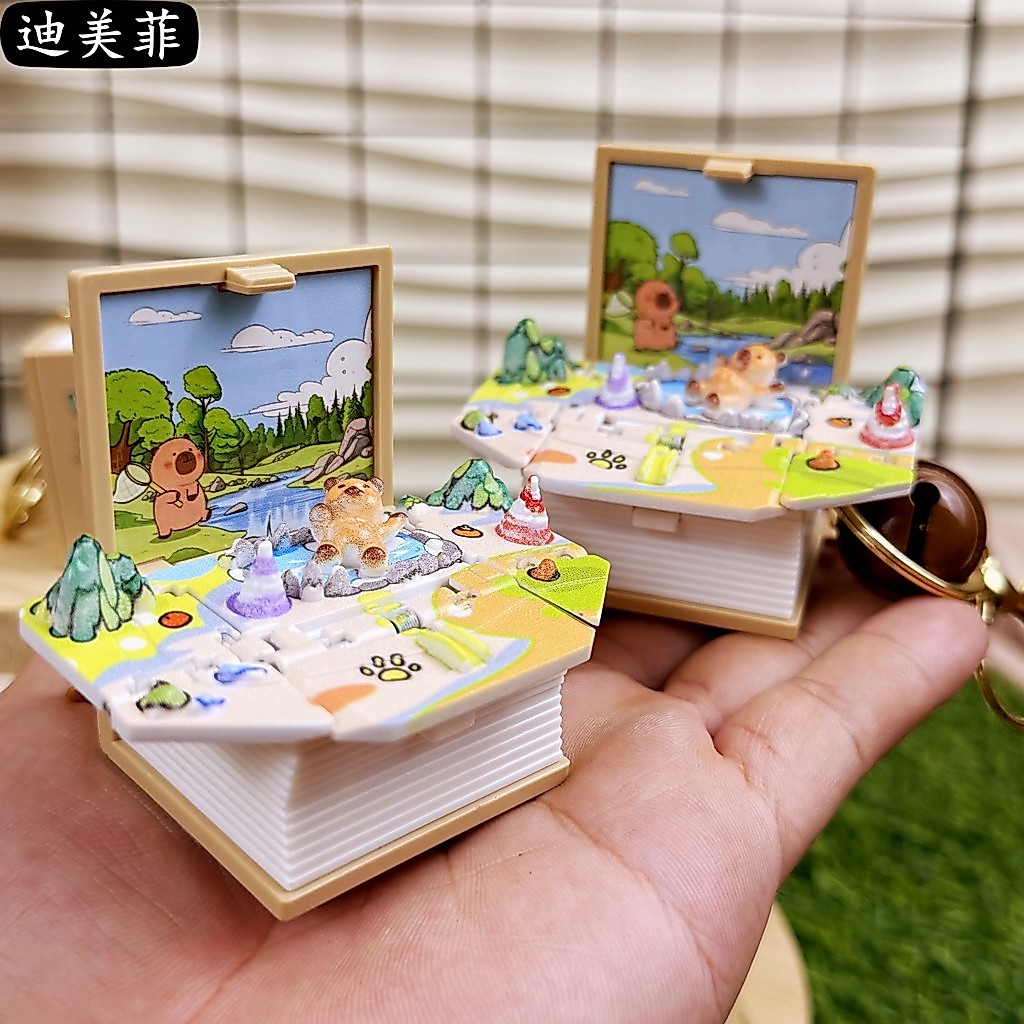 2026 สไตล์ใหม่การ์ตูน 3D Pop-up Book Capybara ระเบิดพับพวงกุญแจ Kapibara Cultural Creative จี้ Creative Magic Book ของขวัญ