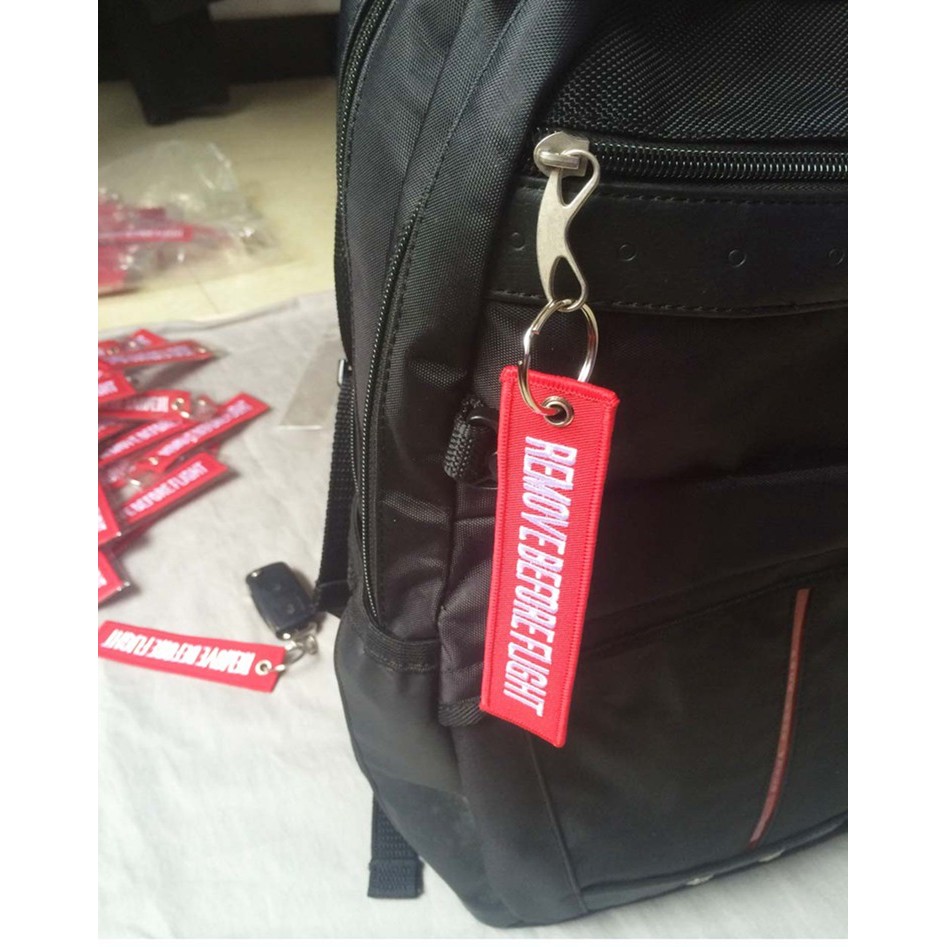 BEFORE FLIGHT หยิบคําเตือนสีแดงการบินสโลแกนเย็บปักถักร้อย REMOVE BEFORE FLIGHT พวงกุญแจ