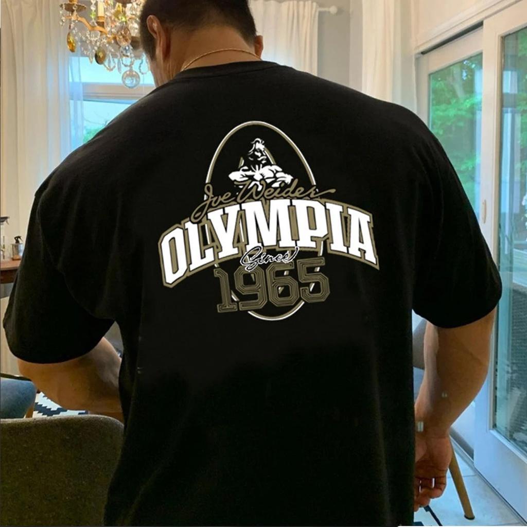 เสื้อยืดโอเวอร์ไซส์ผู้ชายสีดํามีโลโก้ Olympia แม่ลายจริง 1965 Viral Gym Binaraga Community