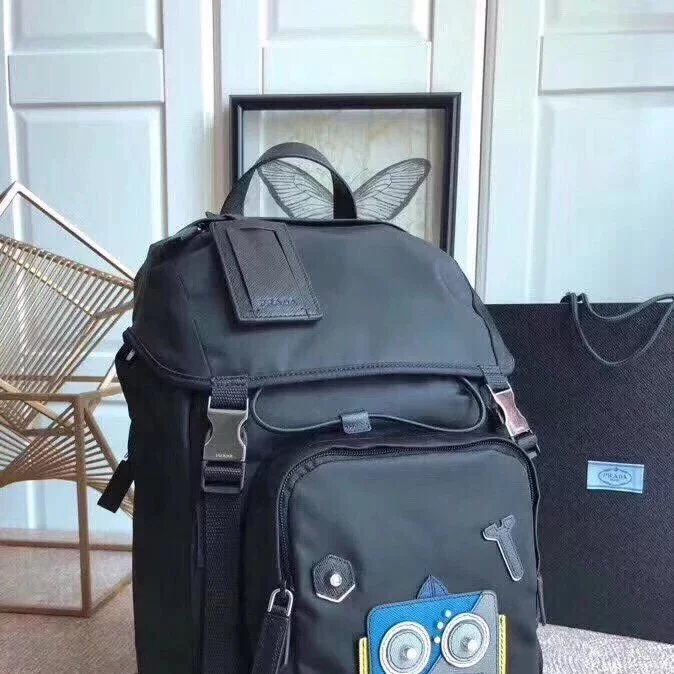 PRADA กระเป๋าเป้สะพายหลัง Oxford ผ้าผู้ชายกระเป๋าเป้สะพายหลังเดินทางหุ่นยนต์ 2vz135 แฟชั่นปีนเขากระเ