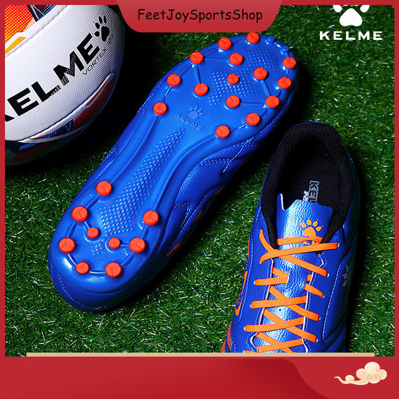 Kelme รองเท้าฟุตบอลเด็กผู้ใหญ่ Ag เล็บกลมสําหรับการแข่งขันฟุตบอลการฝึกอบรมรองเท้ากีฬาสนามหญ้าเทียม