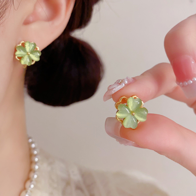 ต่างหูโอปอลสีเขียวดีไซน์เรียบหรู มีลายเหมือนดอกไม้สี่แฉกและมีประกายสวยงาม