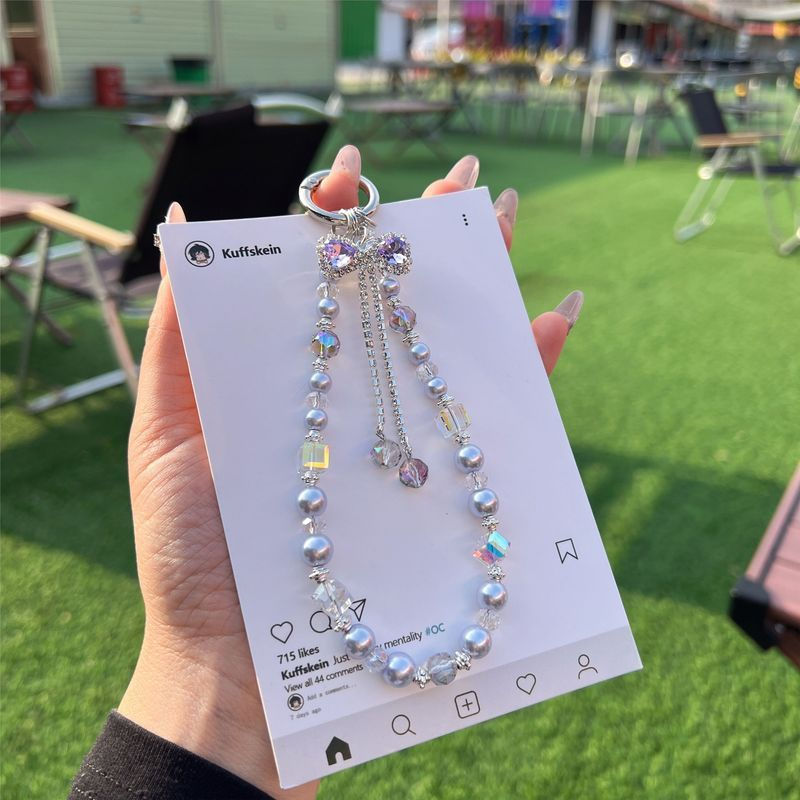 หรูหราความรู้สึกระดับไฮเอนด์พู่สีม่วงมุกโทรศัพท์โซ่ใหม่เคสโทรศัพท์เชือกเส้นเล็กโบว์พวงกุญแจ