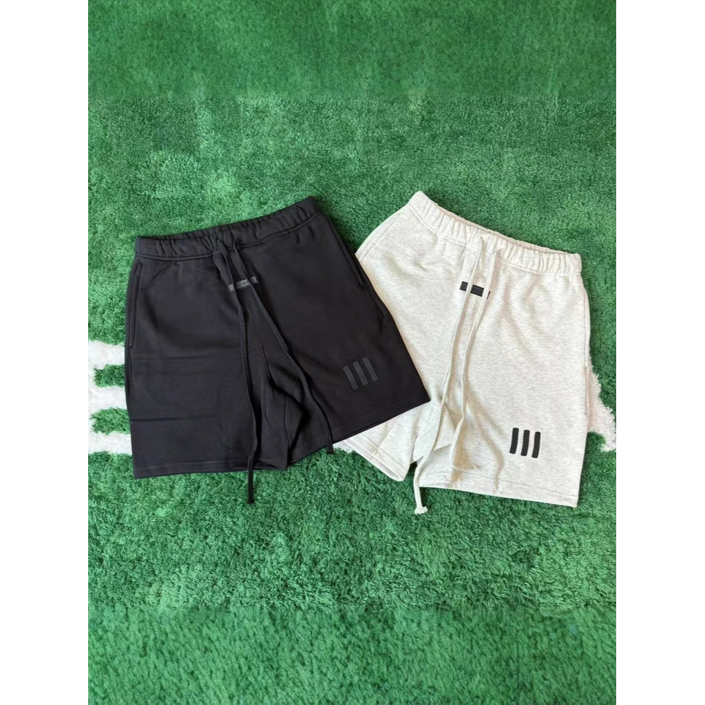 กางเกงขาสั้นสำหรับทั้งผู้ชายและผู้หญิง ออกแบบโดย FEAR OF GOD ESSENTIALS พร้อมลายเส้นสามแถบในสไตล์.st