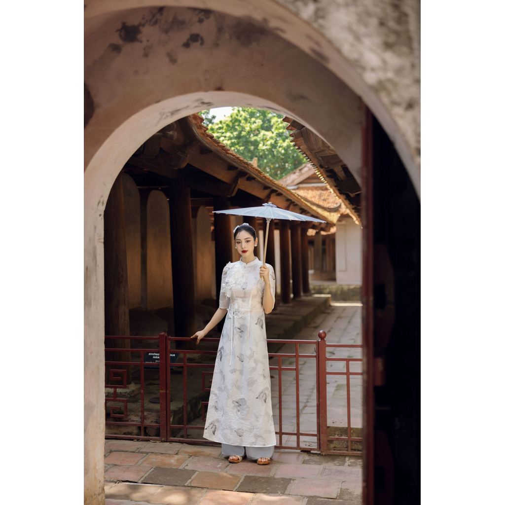 BDA50157 - ผ้าไหมสมัยใหม่ ao dai ทรงหลวม คอรถไฟ แขนปิดไหล่ พองเล็กน้อย สองแผง แอพดอกไม้ 3D ซิปหลัง -