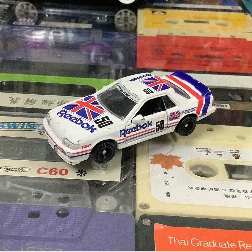 โมเดลรถเหล็กมือสอง 1/62 tomica 50th hasemi masahiro : reebok nissan skyline r31 สภาพปานกลาง มีริ้วรอ
