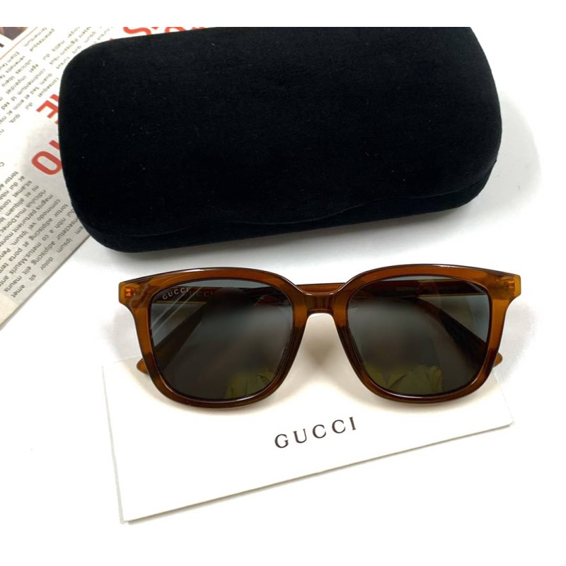 แว่นกันแดด Gucci ทรงเหลี่ยมใส่เข้าหน้า กรอบสีน้ำตาล เลนส์สีเทาดำ ขาแว่นมีโลโก้ Gucci สีทอง