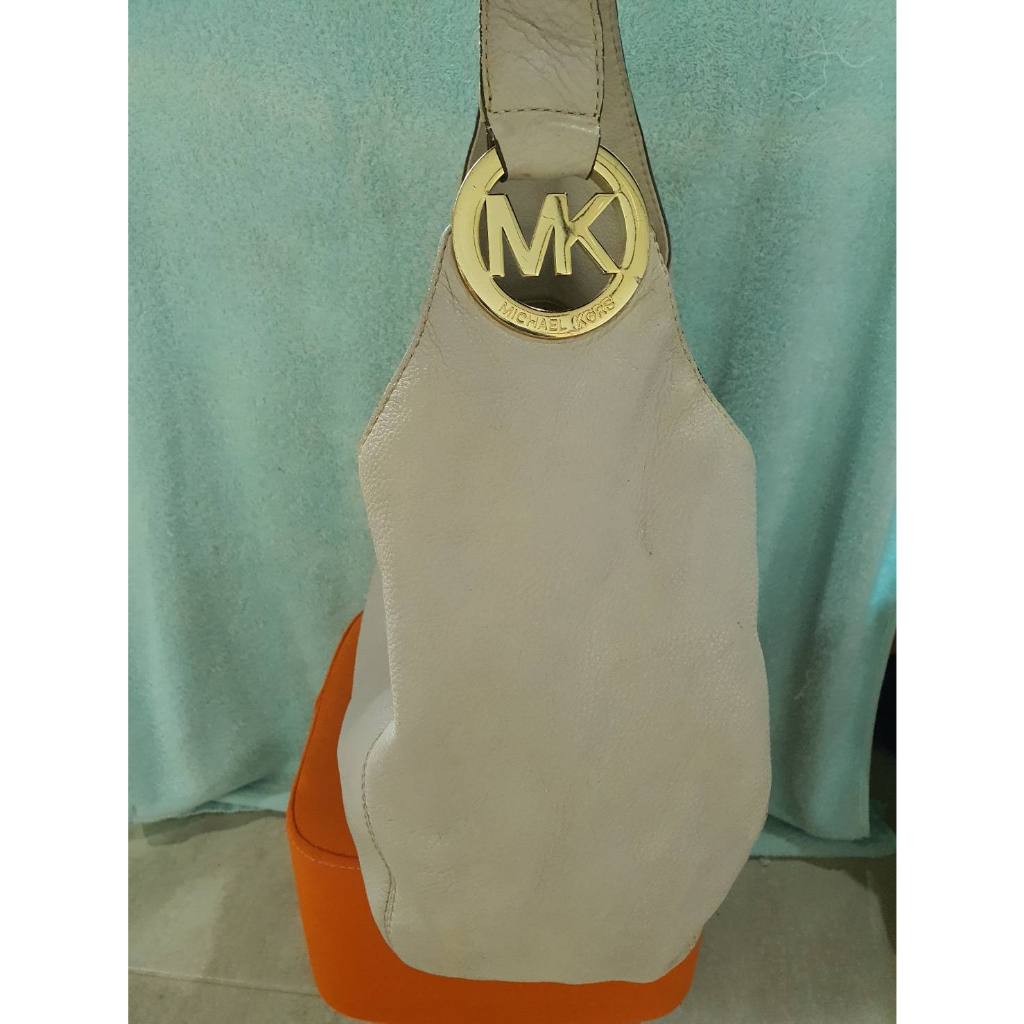กระเป๋าแบรนด์ MK แท้💯 หนังแท้ รุ่น fulton large logo สะพายข้างทรงถ่วงสีครีม สวยเก๋เจ้าของขายเอง 650 บาท