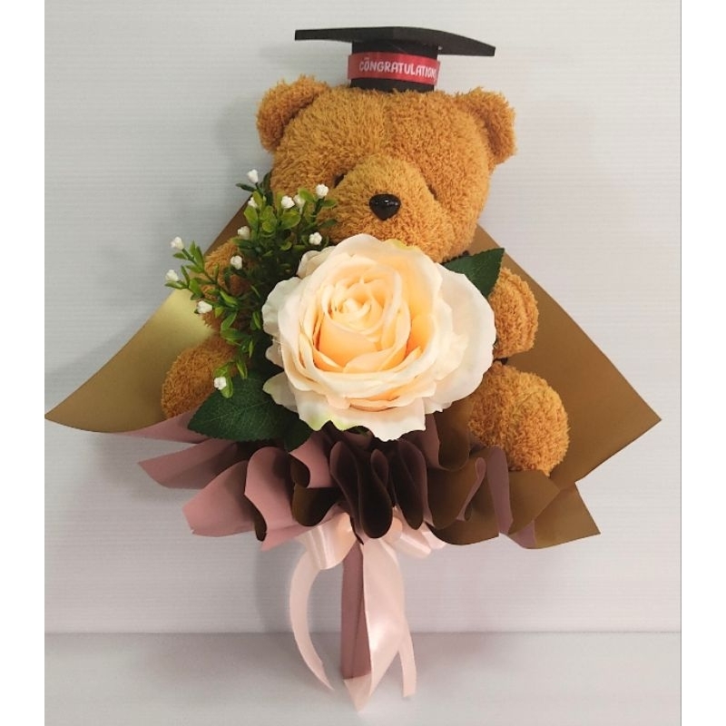ช่อดอกไม้รับปริญา ตุ๊กตารับปริญญา   ช่อตุ๊กตาหมีรับปริญญา ช่อดอกไม้ ขนาด กว้าง 28 ซม. สูง 37 ซม.(กุหลาบสีพีชดอกใหญ่)