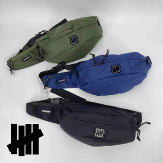 UNDEFEATED WAIST BAG  กระเป๋าคาดอก คาดเอว รุ่นยอดนิยมจาก Undefeated  ไซส์กลางตัวกระเป๋ามีช่อง หลัก 2 ช่อง