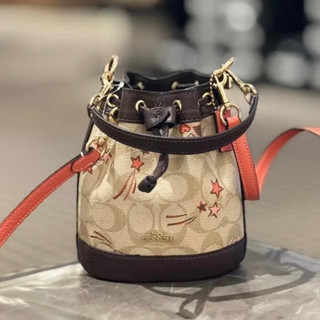 (ผ่อน0%) กระเป๋าทรงบัคเก็ต สะพทยข้าง COACH MINI DEMPSEY BUCKET BAG IN SIGNATURE CANVAS CK524 สายสีน้ำตาล ลายดาว หัวใจ