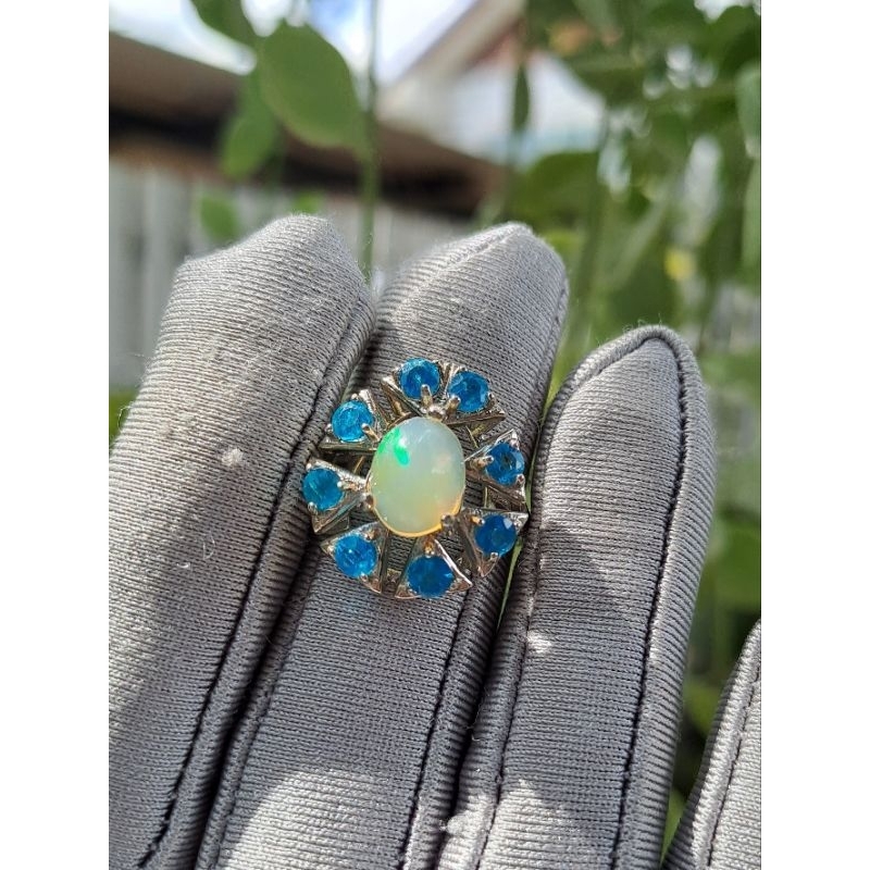 แหวนไวท์โอปอลหลังเบี้ย ล้อมด้วยพลอยสีฟ้าสด บลูอะพาร์ไทต์ (Blue Apatite)