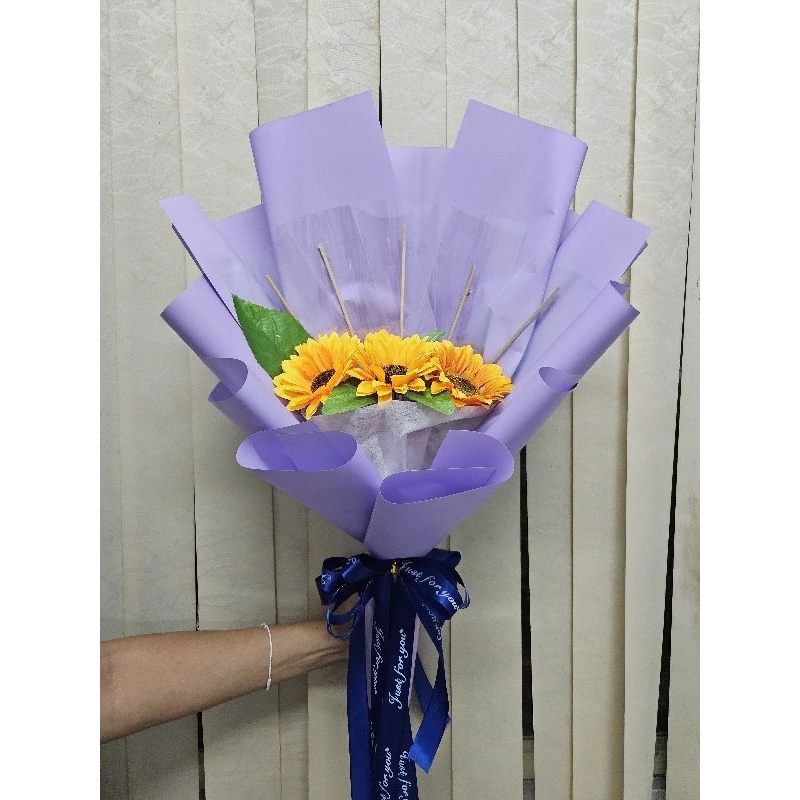 ช่อดอกไม้รับปริญญาดอกทานตะวัน 3 ดอก กระดาษสีม่วงพร้อมที่ใส่ธนบัตร 5 ใบ