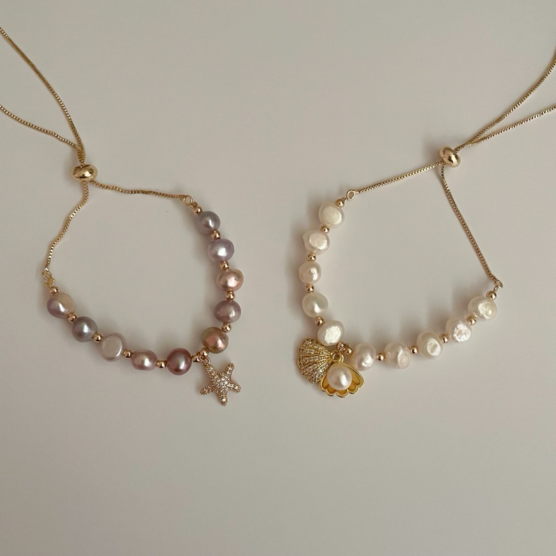 Shellandgold - สร้อยข้อมือมุกน้ำจืดแท้ แบบรูดปรับระดับ มาพร้อมจี้เปลือกหอยตลับ และ จี้ปลาดาว มีให้เลือก 2 สี