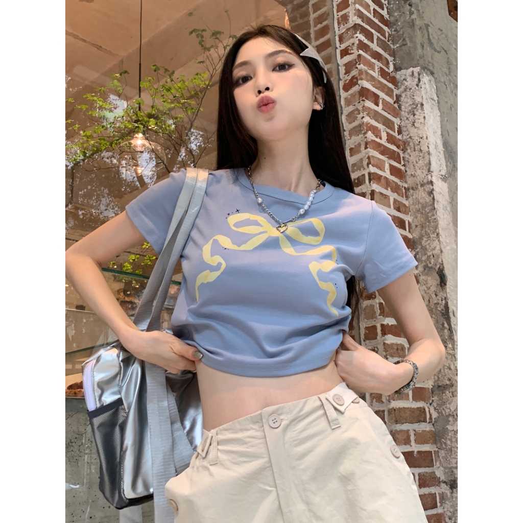เสื้อยืดผู้หญิง แขนสั้น ปาดสะดือ พิมพ์ลายโบว์ที่หน้าอก