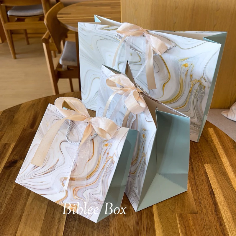 ꒰1ใบ꒱ถุงกระดาษ ลายหินอ่อนเป็นคลื่นๆด้านข้างสีฟ้าครามอ่อน ริบบิ้นทูโทน สีทอง(อ่อน/เข้ม)-แก้ว