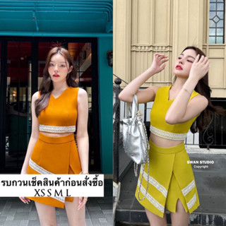 เซทเสื้อครอปแขนกุดสีส้มอิฐชายแต่งด้วยแถบลูกไม้ มากับกระโปรงกางเกง ด้านหน้าเป็นกระโปรง ซ้อนด้วยกางเกง มีผ่าตรงหน้าขา แต่ง