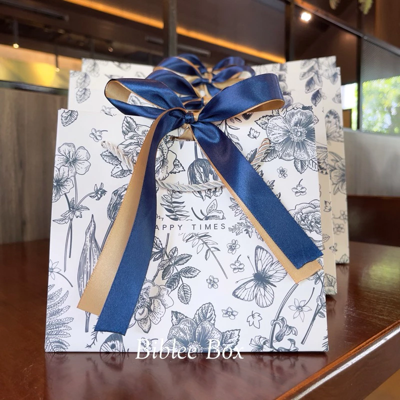 ꒰1ใบ꒱ถุงกระดาษ HAPPY TIMES สีขาวพิมพ์ลายกุหลาบคริสตี้ ทิวลิป เซนทอเรีย ริบบิ้นทูโทน สีทอง-น้ำเงิน