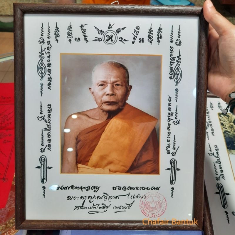 ภาพพระครูญาณวิลาศ หลวงพ่อแดง วัดเขาบันไดอิฐ อ.เมือง จ.เพชรบุรี วาระปี2565 ขนาด 27.5 x 32.5 ซม. (ใส่กรอบเดิมแท้จากวัด)
