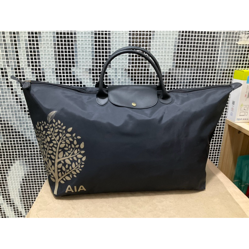 กระเป๋า AIA สีดำ เนื้อกระเป๋าเป็นแบบมัน เรียบหรู ดูแพง ใส่ของเยอะ เทียบเท่าแบรนด์  มือหนึ่ง