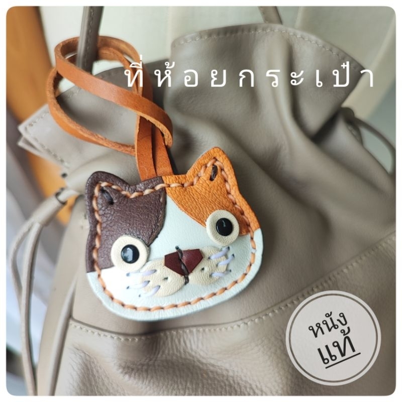 ที่ห้อยกระเป๋าหนังแท้ รูปแมว ผ้าพันหูกระเป๋า จี้ห้อยกระเป๋าน่ารัก ใช้ได้กับกระเป๋าเป้และกุญแจ ของฝากพรีเมียม