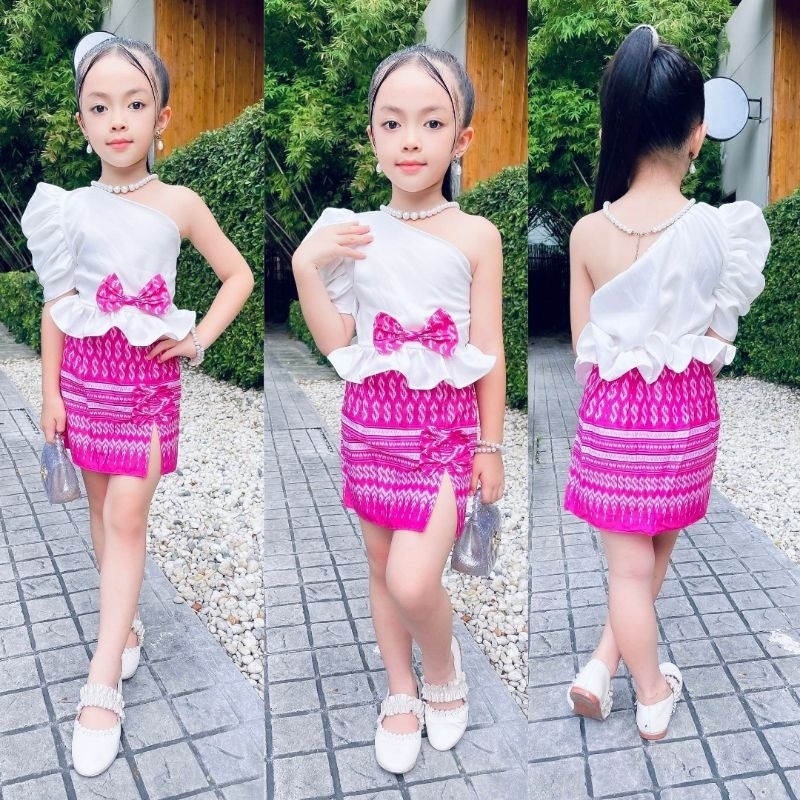 ชุดไทยเด็ก ชุดไทยเด็กผู้หญิง ชุดไทยเด็กหญิง ชุดไทยประยุกต์สีชมพู เสื้อเปิดไหล่เอวระบาย+กระโปรงผ่าหน้าผ้าไทยพิมพ์SSS