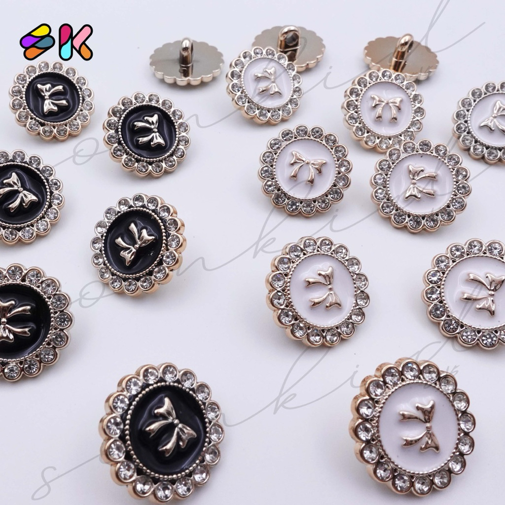 กระดุมลายโบว์ล้อมเพชร สีขาว และ สีดำ มี2ขนาด 17มิลและ20มิล มีขาสอยก้น