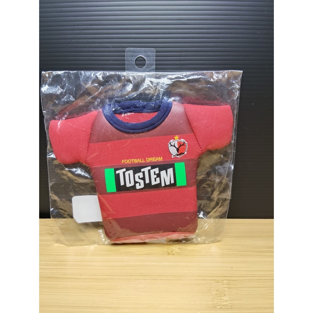 กุญแจรูปเสื้อฟุตบอล 
มีข้อความ "FOOTBALL DREAM" และ "TOSTEM" บนเสื้อ

