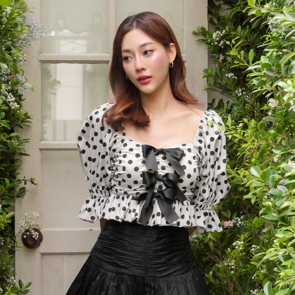 LUCA STUDIO_Willow crop top เสื้อครอปผ้าโพลีเอสเตอร์ พิมพ์ลายจุด (Polka dot) สีดำบนพื้นสีขาว ตกแต่งโบว์ช่วงอก