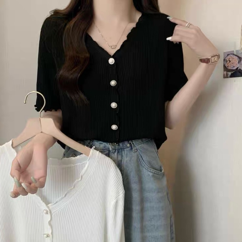เสื้อแขนสั้น ทรง คาร์ดิแกน (Cardigan) เสื้อดำ แบบกระดุมหน้า เนื้อผ้าน่าจะเป็นผ้าถัก (knit) แบบบางเบา มีความยืดหยุ่น
