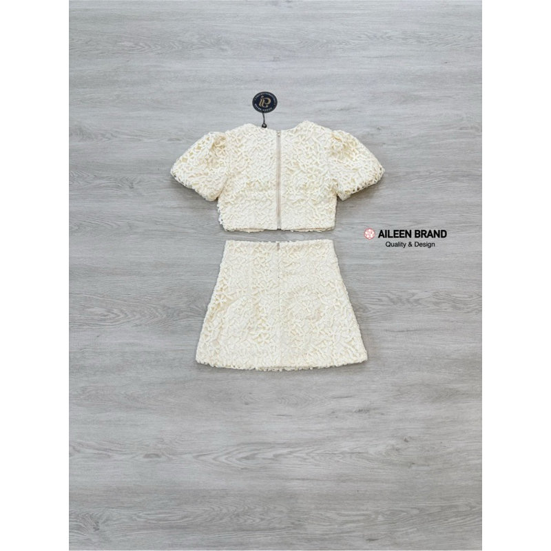 Aileen เสื้อคอป ลูกไม้สีครีม แขนสั้น แต่งจั้มสม๊อคแขน ดีเทลแต่งสายผู้โบว์หน้า มีซิปหลัง แมทซ์กับกระโปรงสั้นลูกไม้