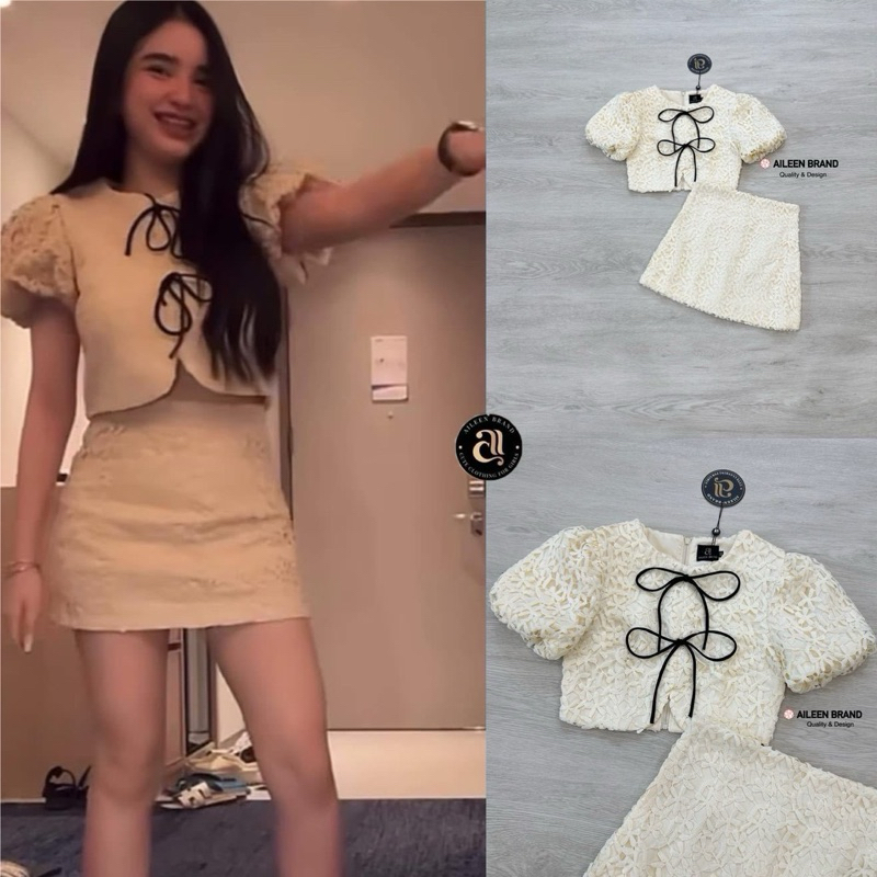 Aileen เสื้อคอป ลูกไม้สีครีม แขนสั้น แต่งจั้มสม๊อคแขน ดีเทลแต่งสายผู้โบว์หน้า มีซิปหลัง แมทซ์กับกระโปรงสั้นลูกไม้